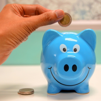 mano mette moneta in salvadanaio