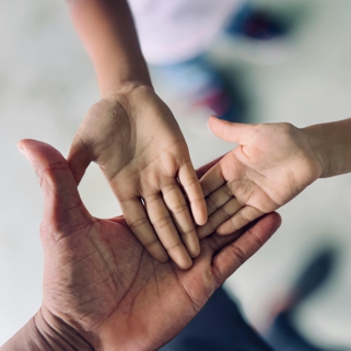 2 mani di bambino in una mano adulta